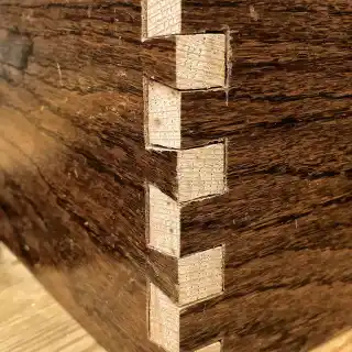 Showing the 'white' cut ends of the dovetails punching through the original brown lacquer finish